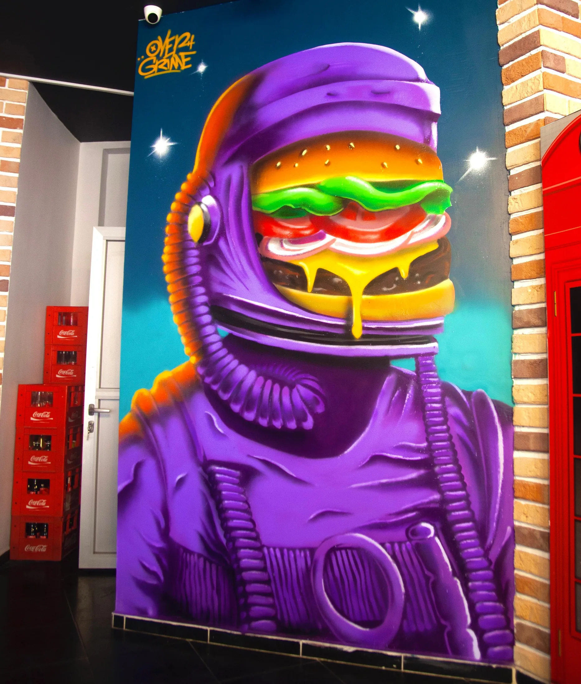 Mor kapüşonlu burger karakterinin bulunduğu mağaza duvarı